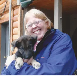 A woman holding a puppy in her arms.